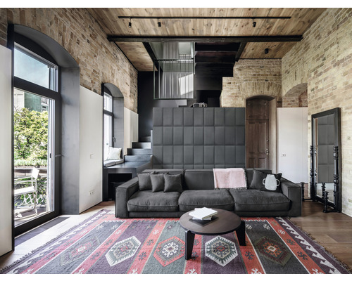 Obývacia izba s pohovkou, kobercom a tehlovou stenou