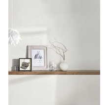 Obývacia izba s tapetou, policou a dekoratívnymi prvkami, ako sú rámy a váza