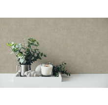 Dekoratívne zátišie scéna s eukalyptovými vetvami, sviečkou a dekoratívnymi prvkami pred štruktúrovanou stenou