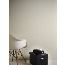 Interiérový pohľad so štruktúrovanou tapetou na stene, doplnený stoličkou a úložnými boxmi