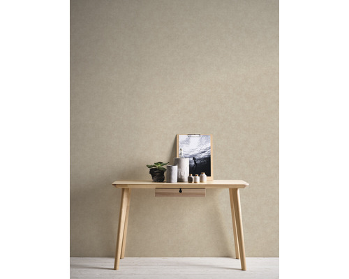 Dekoratívna scéna so svetlým dreveným stolom, rastlinou, sviečkami a obrázkom na stene