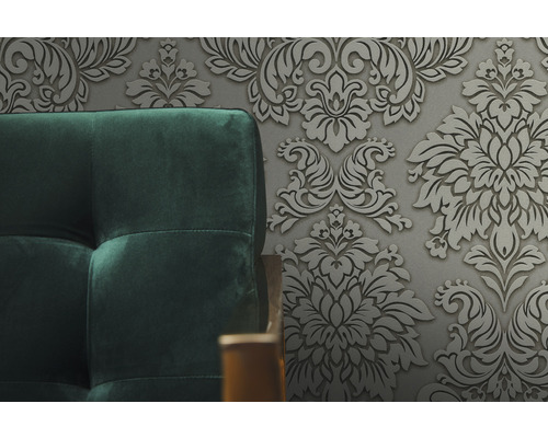 Detail čalúnenej pohovky pred kvetinovou tapetou