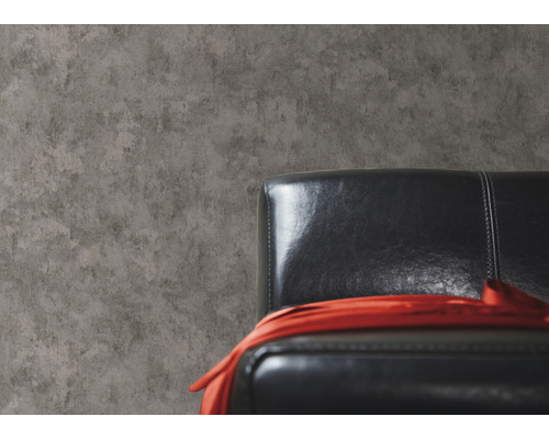 Tapeta s betónovým vzhľadom vedľa čierneho koženého kresla