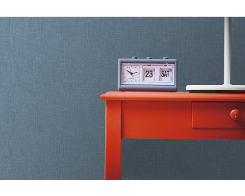 Scéna so sivým kalendárom na červenom stole pred štruktúrovanou stenou