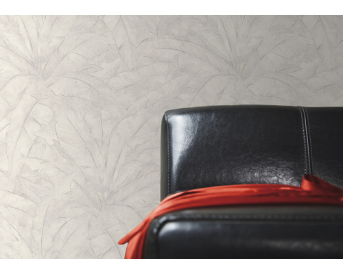 Nástenná dekorácia s motívom listov vedľa čierneho koženého kresla