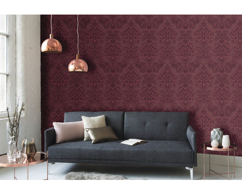 Obývacia izba so sivou pohovkou, vzorovanou tapetou a závesnými svetlami