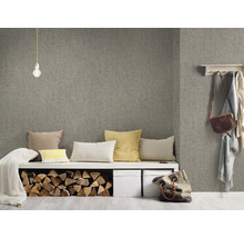 Obývacia izba so sivou textilnou tapetou, lavica s vankúšmi, polená a úložné boxy