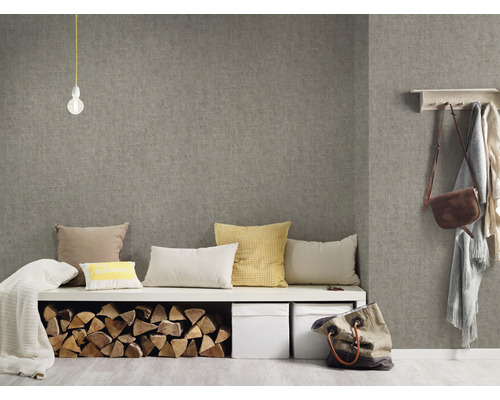 Obývacia izba so sivou textilnou tapetou, lavica s vankúšmi, polená a úložné boxy