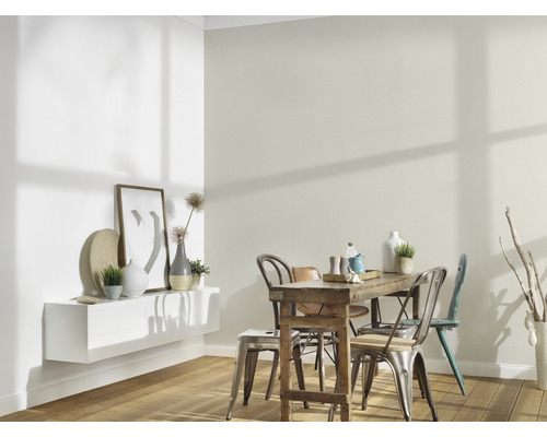 Svetlá jedáleň s dreveným stolom, stoličkami a dekoratívnymi prvkami na stene