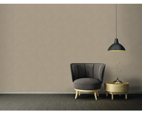 Interiér s kreslom, odkladacím stolíkom a závesnou lampou pred béžovou stenou