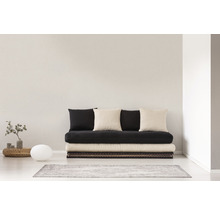 Obývacia izba s futónovou posteľou, vankúšmi a dekoráciou