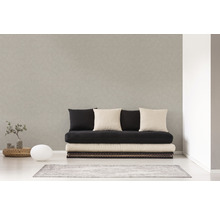 Svetlá izba s pohovkou, niekoľkými vankúšmi, malým stolom, lampou a kobercom.