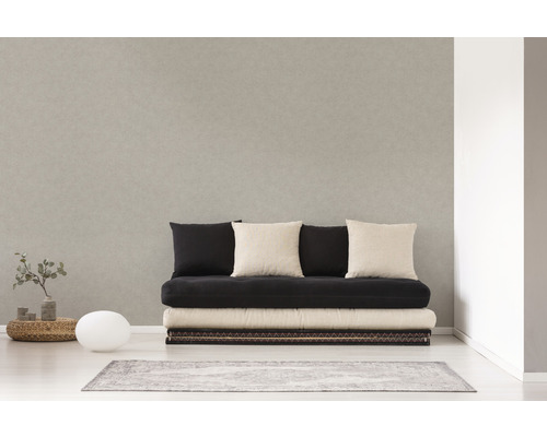 Svetlá izba s pohovkou, niekoľkými vankúšmi, malým stolom, lampou a kobercom.