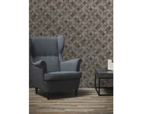 Obývacia izba s kreslom, stolom a geometrickou tapetou