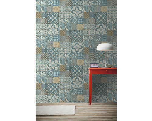 Pohľad na izbu s tapetou so vzorom, červeným stolom a lampou