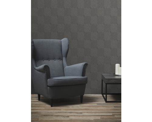 Obývacia izba s kreslom s opierkami, konferenčným stolíkom a vzorovanou tapetou