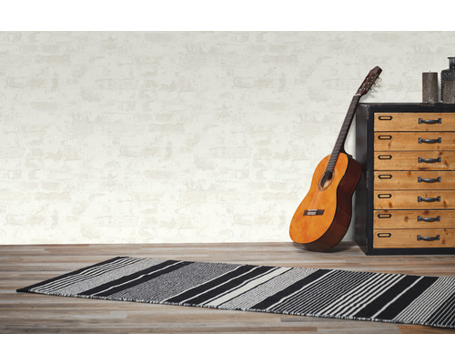 Scéna so vzorovanou rohožkou, gitarou a komodou v izbe