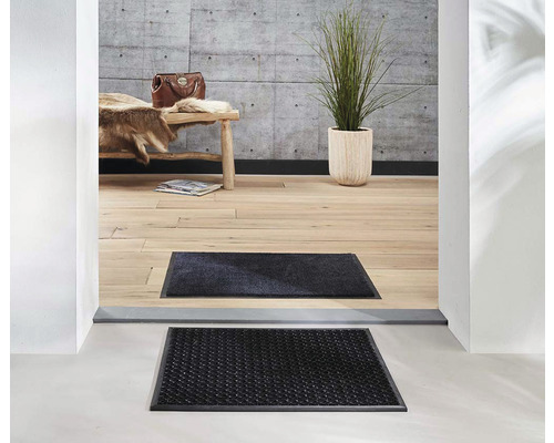 Scéna s rohožkami pred vchodom do domu.