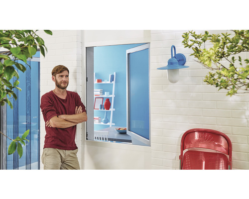 Muž stojí pred domom so sieťou proti hmyzu a vonkajším svetlom