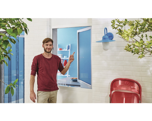 Muž ukazuje na okennú sieť proti hmyzu v obytnom priestore