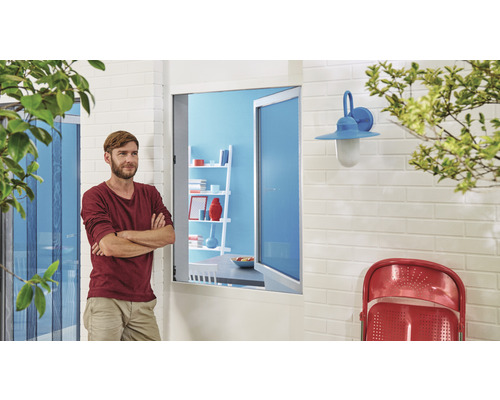 Muž pred terasovými dverami so sieťou proti hmyzu, nástenným svetlom a stoličkou