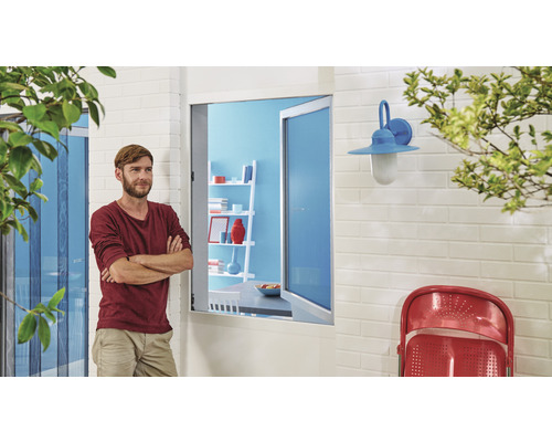 Vonkajší pohľad na dom so sieťou proti hmyzu, oknom, nástennou lampou a mužom