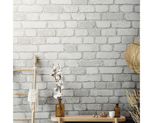 Nástenná dekorácia s tapetou imitujúcou murivo, dreveným rebríkom a dekoráciami