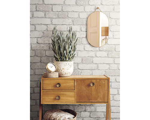 Dekoratívna izba s tapetou imitujúcou tehly, zrkadlom a komodou