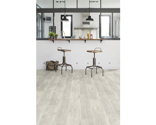 Svetlá kuchyňa s drevenou podlahou a barovými stoličkami.