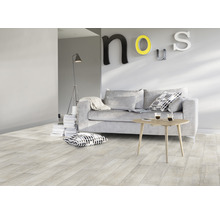 Obývacia izba so svetlou drevenou podlahou, pohovkou, stolom a dekoráciou