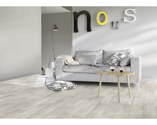 Obývacia izba so svetlou drevenou podlahou, pohovkou, stolom a dekoráciou