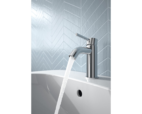 Kovová vodovodná batéria na umývadle s tečúcou vodou