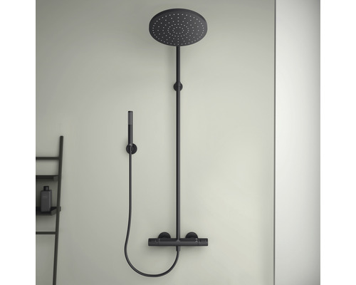 Čierna sprchová armatúra s hlavovou a ručnou sprchou namontovaná na stene.