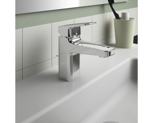 Lesklá armatúra na umývadle v kúpeľni.