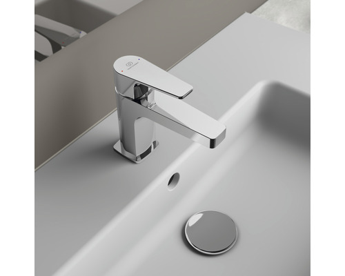 Lesklá umývadlová batéria na bielom umývadle s výpustkou