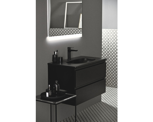 Kúpeľňa s čiernou skrinkou pod umývadlo, umývadlom na dosku a osvetleným zrkadlom