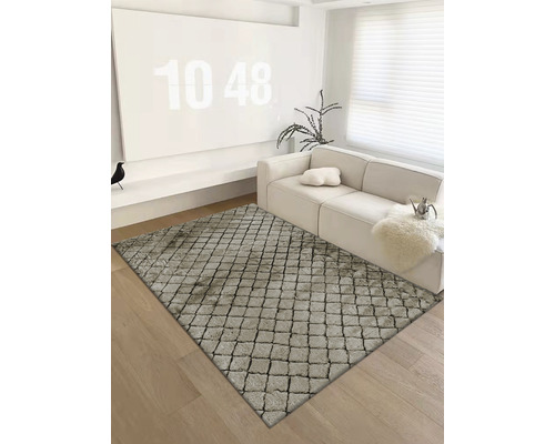 Obývacia izba s kobercom so vzorom dlažobných kociek, pohovkou a dekoráciami.