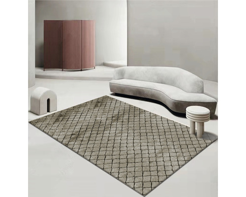 Béžový vzorovaný koberec vo svetlej miestnosti s pohovkou a nábytkom