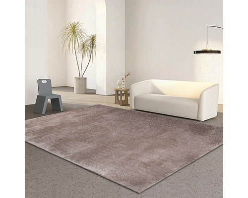 Obývacia izba s hnedým kobercom, bielou pohovkou a sivou stoličkou.