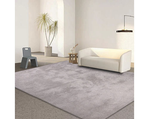 Svetlý obývací priestor s kobercom, pohovkou a stoličkou