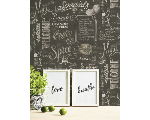 Dekoratívna tapeta na tabuľu s kriedovým písmom v miestnosti s črepníkovou rastlinou a rámikmi na fotografie