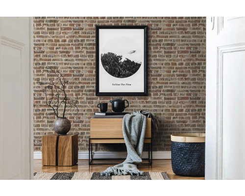 Dekoratívna obývacia izba s tapetou s motívom tehál, drevenou komodou a zodpovedajúcimi doplnkami.