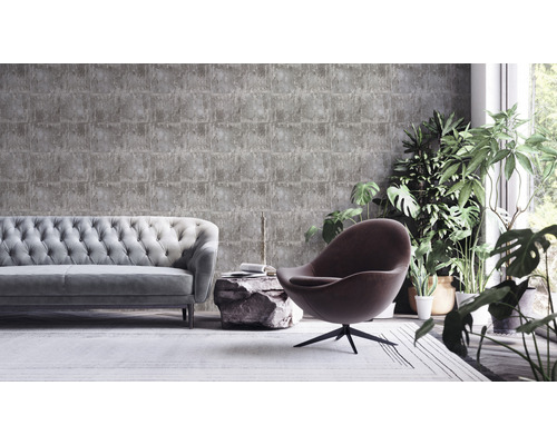 Obývacia izba so sivou tapetou v kamennom vzhľade, pohovkou, kreslom a izbovými rastlinami