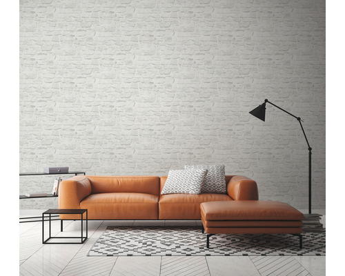 Obývacia izba s pohovkou, stoličkou, lampou a tapetou so vzorom tehál