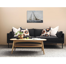 Obývacia izba s pohovkou, dreveným stolom a obrazom plachetníc