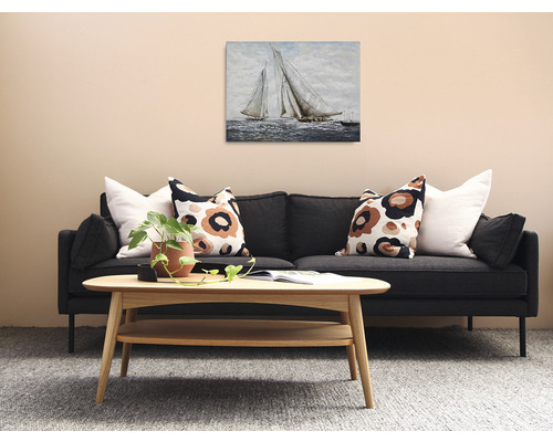 Obývacia izba s pohovkou, dreveným stolom a obrazom plachetníc