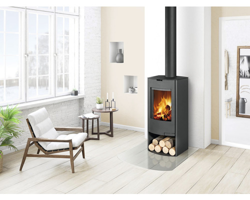 Obývacia izba s krbovými kachľami, kreslom a drevenou podlahou