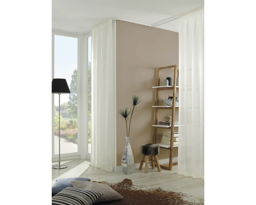 Svetlý obývací priestor s oknom, závesmi, regálom a dekoráciou