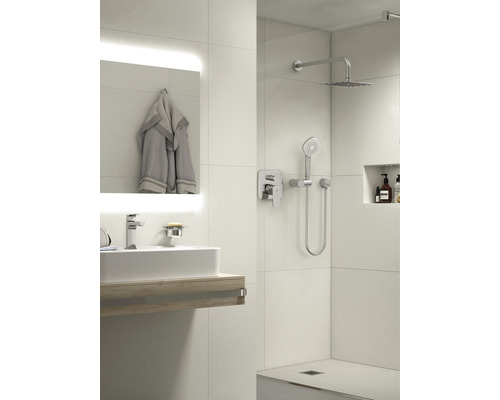 Svetlá kúpeľňa s umývadlom, zrkadlom, uterákom a sprchou