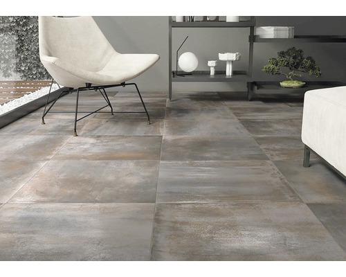 Interiér s keramickou dlažbou so vzhľadom kameňa, kreslom a regálom